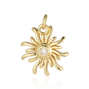 Detail of a golden sun pendant with center zircon stone and polished metal rays