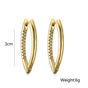 Detalle macro de los pendientes en forma de V bañados en oro con circonitas brillantes