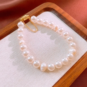 Dettaglio del bracciale di perle d'acqua dolce con chiusura magnetica dorata e catenella