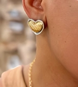 Close-up of two-tone heart earrings featuring golden ripple texture and silver frames