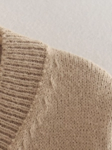 Detail of oatmeal knit sweater showing ribbed neckline and soft fuzzy texture