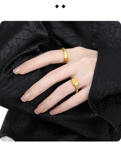 Macro detail of geometric faceted and rectangular brushed gold rings on model hand