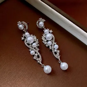 Long silver drop earrings featuring vintage tassels with sparkling crystals and pearls