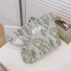 Close-up of floral canvas toiletry bag with silver zipper and simple wish label