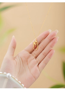 Macro view of 925 silver ginkgo leaf necklace with red agate pendant in palm