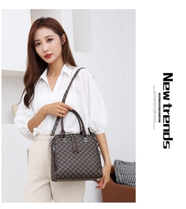 Detail view of brown geometric pattern handbag with top handles and adjustable shoulder strap