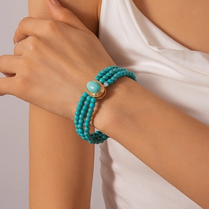 Detailed close-up of a bohemian triple-layer turquoise bead choker with oval stone