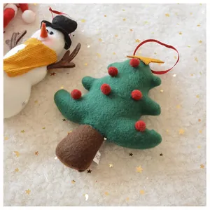 Detailed texture of handmade plush felt snowman and Christmas tree festive ornaments
