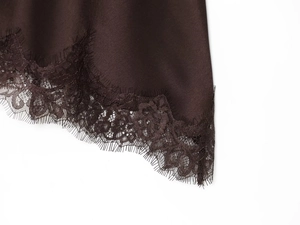 Close-up of deep coffee satin fabric with delicate black eyelash lace trim detail