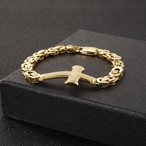 Detail of golden Byzantine chain bracelet with cross pendant on black gift box