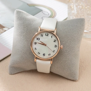 Elegant white leather quartz watch with rose gold case on a velvet display pillow