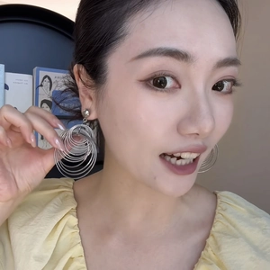 Close-up of model wearing stylish silver layered circle earrings with a sleek metal finish