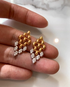 Gros plan sur les zircons étincelants des boucles d'oreilles bicolores or et argent