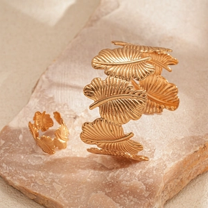 Detailed macro view of golden leaf texture on the open bracelet and matching ring