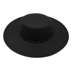 Detailed close-up of a black wool flat top hat featuring a gold studded leather band