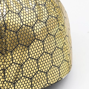 Macro shot of metallic gold hexagonal honeycomb texture on cotton baseball cap