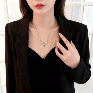 Collier élégant avec pendentif ailes d'ange et épée en acier argenté sur un mannequin