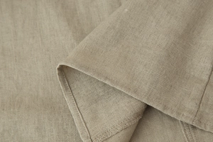 Macro shot of beige linen fabric texture and precise stitching on sleeveless maxi dress