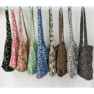 Nine stylish canvas tote bags featuring leopard and floral prints hanging in a row