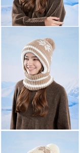 Close-up of winter knit hat with white snowflake patterns and large faux fur pompom detail