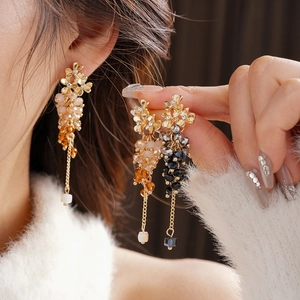 Close-up of sparkling flower tassel earrings with champagne and grey crystal bead fringe