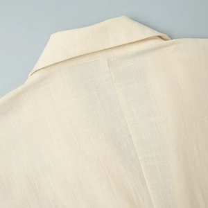 Detailed close-up of beige linen sleeveless dress collar with professional stitching