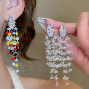 Detail of long fringe earrings with marquise crystal and colorful heart-shaped beads