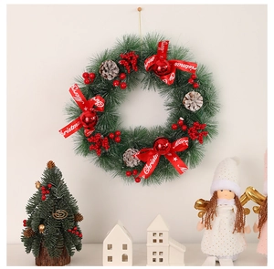 Close-up of a Christmas wreath with pine cones, red berries, and a Merry Christmas ribbon