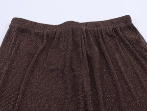 Detail of coffee brown metallic knit pants with elastic waistband and pleated texture