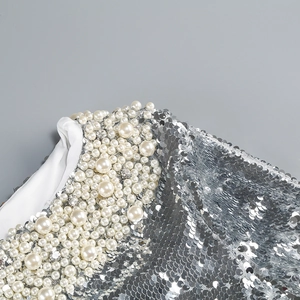 Macro detail of silver sequins and faux pearls on an elegant evening dress gown