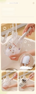 Close-up of a versatile white long-handle brush cleaning various bottles and cups