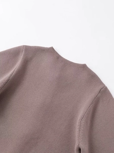 Détail du col rond et de la maille fine sur un cardigan à manches courtes mauve