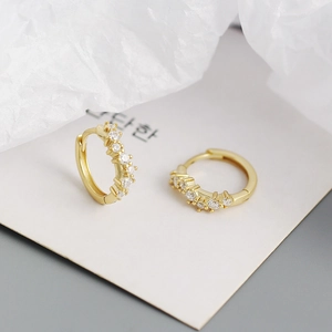 Macro shot of gold-plated geometric wavy hoop earrings with sparkling cubic zirconia