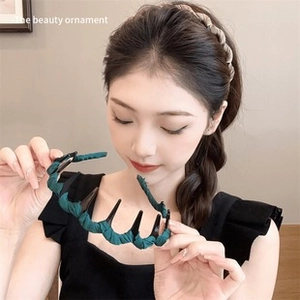 Detail of dark green pleated fabric headband hair comb shown on model with hair texture
