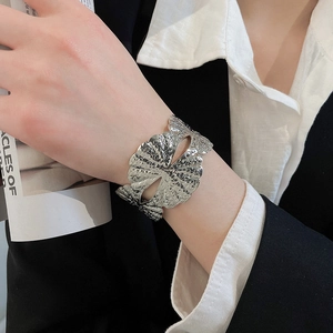 Detailansicht einer silbernen breiten Manschette mit hohlem Blumenmuster Design
