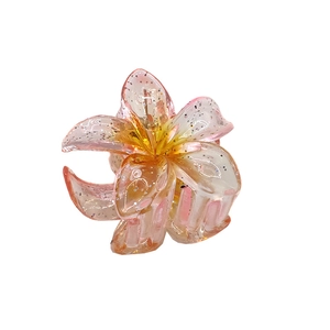 Close-up of 4cm glitter plumeria hair claw with pink orange gradient resin finish