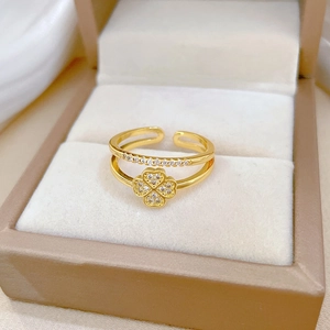 Detail of gold clover ring with pavé zircons on adjustable band in jewelry box