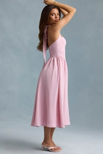 Detail of pink halter neck dress with open back design and flowing midi skirt
