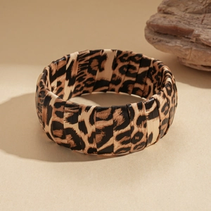 Detail of wide leopard print faux leather cuff bracelet with wrap texture and layered design