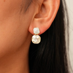 Gros plan de boucles d'oreilles carrées géométriques avec cristaux et plaqué or