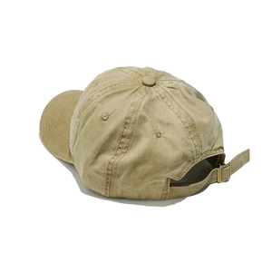 Close-up of khaki washed canvas baseball cap showing metal buckle and back strap detail
