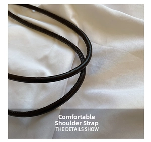 Close-up of deep brown leather tubular strap with fine stitching on white fabric