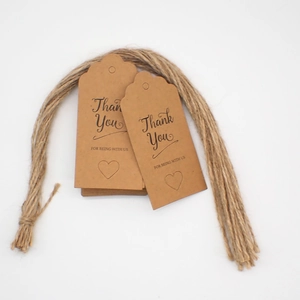 Close-up of brown kraft paper gift tags with jute twine and black heart text