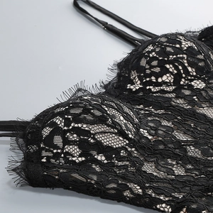 Dettaglio del vestito in pizzo nero con spalline sottili e design a corsetto trasparente