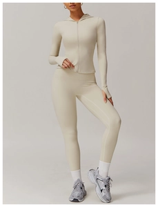 Detailed view of beige yoga set featuring slim fit zip-up jacket with functional thumbholes
