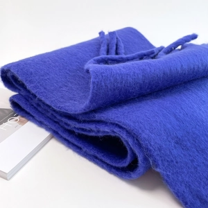 Detail of dark blue mohair scarf with soft plush texture and fringe on white background