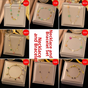 Detail view of gold chain necklaces and bracelets sets with floral and crystal pendants