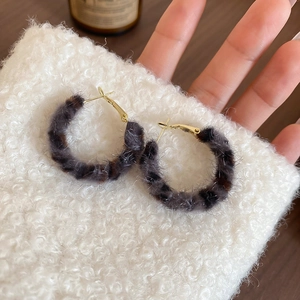 Detailed view of vintage leopard print fur hoop earrings with golden metal hooks