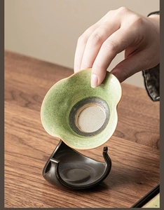Detailed view of handmade ceramic tea strainer with green glaze and fine metal mesh filter