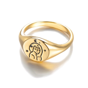 Macro shot of gold signet ring featuring celestial female portrait with star and moon motifs